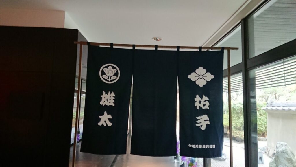 濃紺に白抜きの家紋入り結婚式ののれん