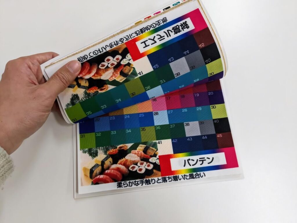 生地の見本帳を開いている